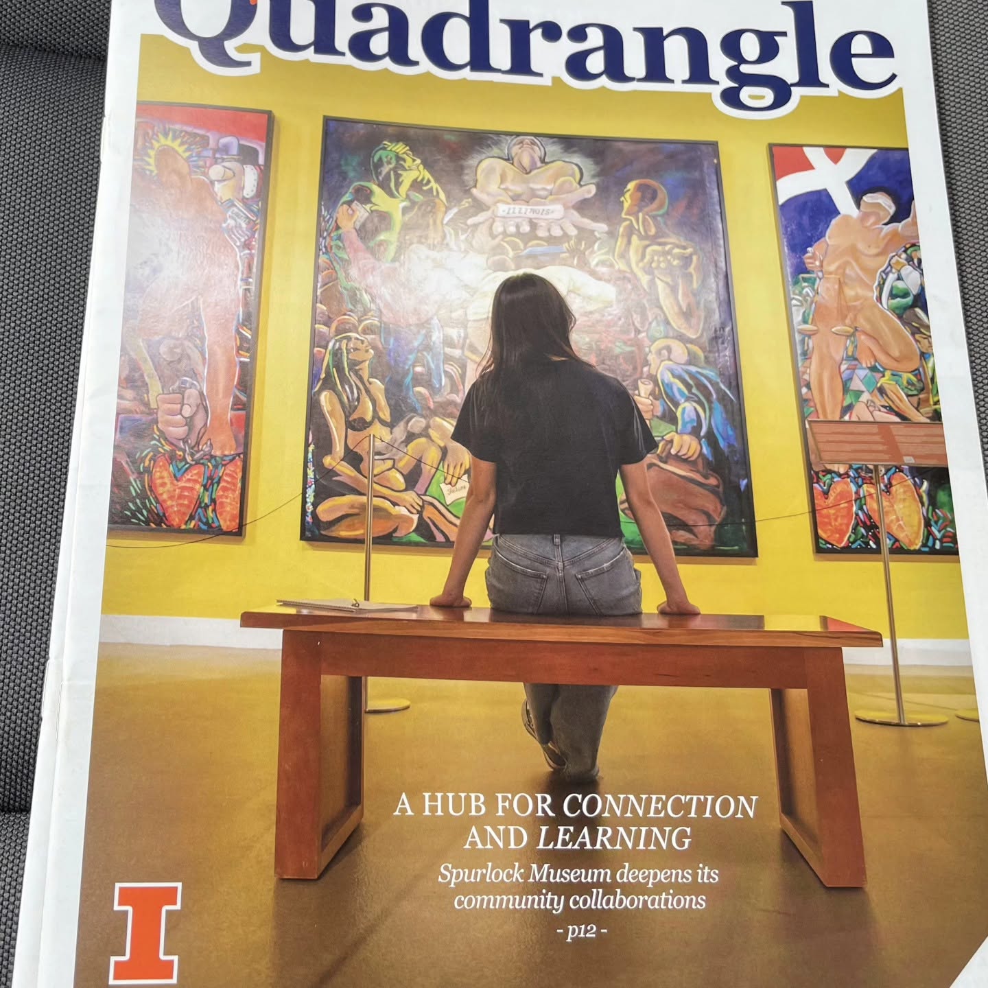 University of Illinois Quadrangle magazine cover showing a student viewing paintings by Oscar Luis Martinez at the Spurlock Museum