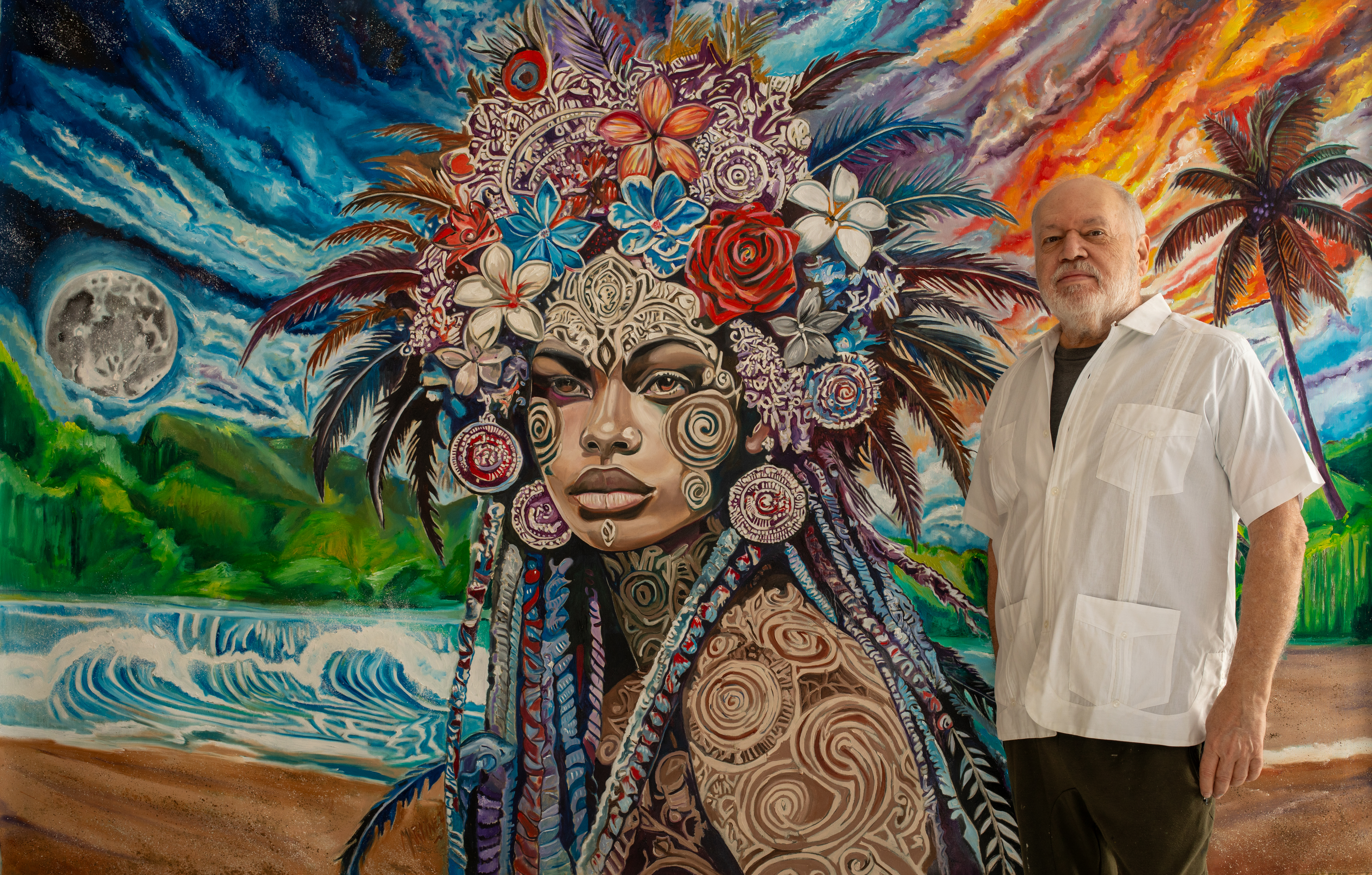 Oscar Luis Martinez standing with one of his monumental paintings
